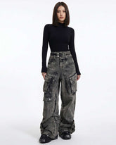 Legs wearing Midnight Rebel Cargo Jeans with multiple oversized pockets, dark-wash denim, and wide-leg fit