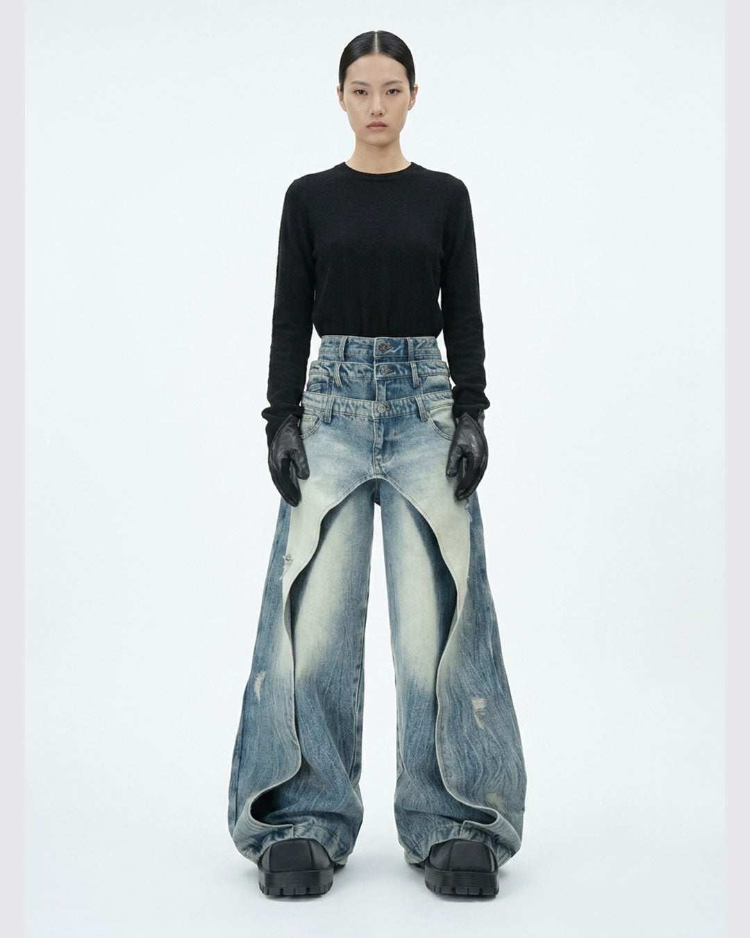 Layered distressed blue jeans with wide-leg silhouette and urban streetwear style