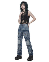 Model wearing distressed baggy patchwork jeans women style with black cropped harness top and platform boots, front view
