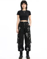 Person wearing black outfit with cross patterns on a white background