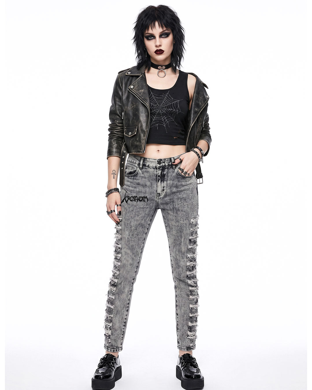 Woman wearing grey skinny jeans women with ripped thigh detailing, styled with black leather jacket and choker