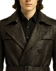 Close-up of black gothic cross leather trench coat with double-breasted front and belted waist detailing