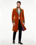 Mens orange coat with black and gold embroidered lapel, cuffs, and long Victorian gothic tailcoat design shown on male model