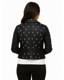 Women’s black leather cropped jacket with metallic silver star studs, styled from the back.