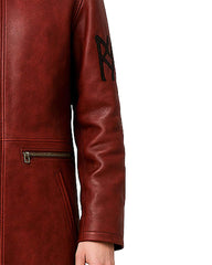 Close-up of maroon hooded gothic leather trench coat sleeve with black embroidery and zippered pocket detail
