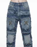 Close-up of patchwork jeans front waist with X-stitched pockets, frayed edges and metal button closure