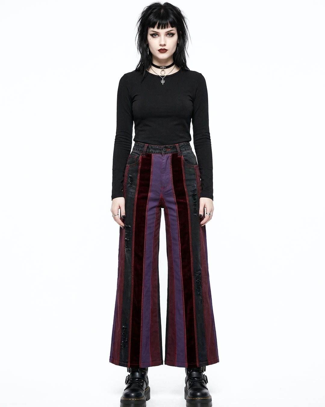 Woman wearing a black top and red and black striped pants on a white background