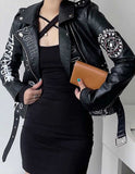 Women’s black graphic faux leather biker jacket with white and red prints, asymmetrical zipper, and belted waist.