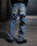 Distressed baggy jeans for men in light blue denim with ripped front panels and bold black graphic artwork on the back leg, shown front and back.