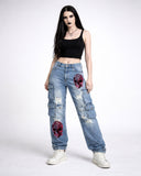 Women's light blue Y2K baggy cargo jeans with pink graphic artwork, lifestyle view