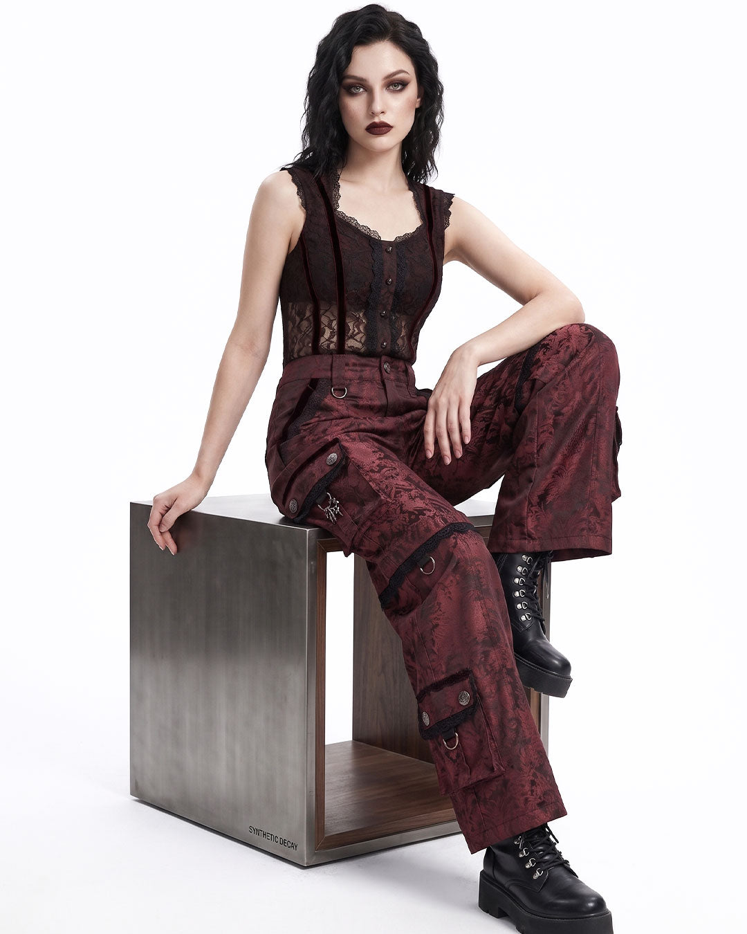 Red goth women cargo pants seated pose on model
