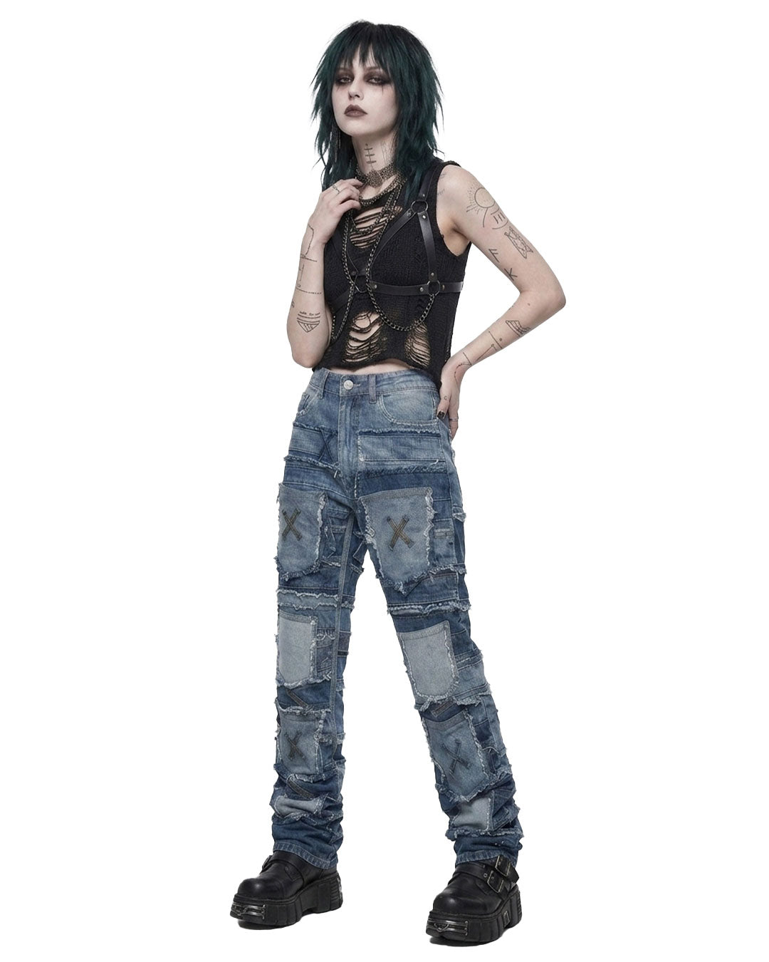 Model wearing distressed baggy patchwork jeans women style with black cropped harness top and platform boots, front view