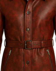 Maroon leather trench coat for men with belted waist, button closure, and zippered pockets.