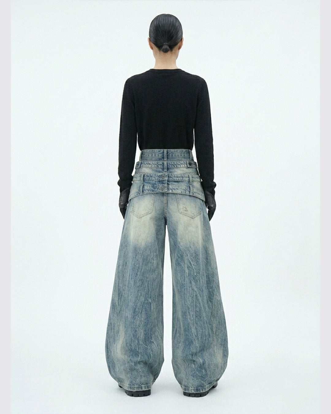 Layered distressed blue jeans with wide-leg silhouette and rugged urban style