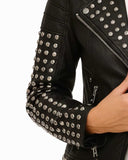 Black studded leather jacket with silver-tone studs and asymmetrical zip closure on a woman's arm
