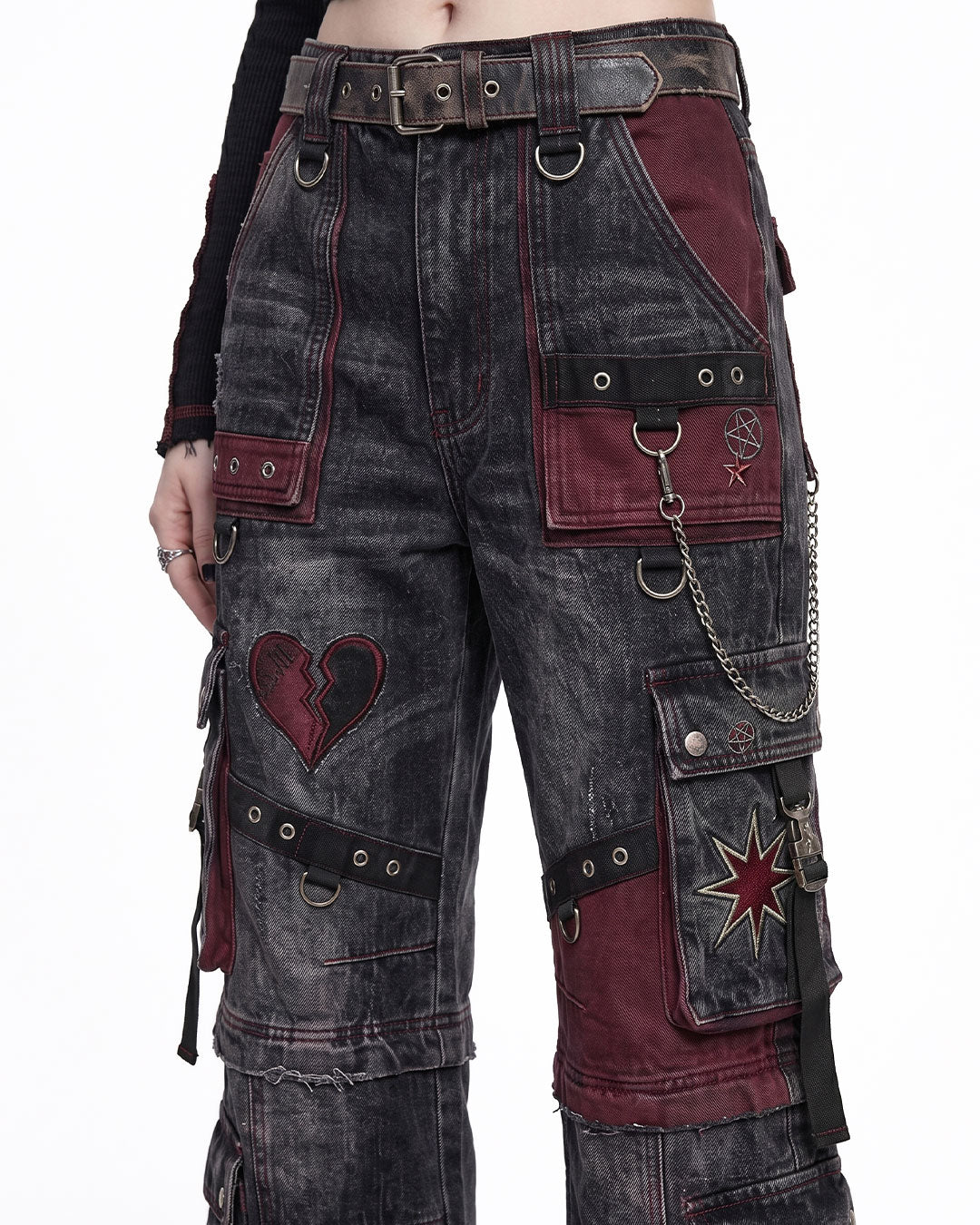 Close-up of women's cargo jeans showing gothic patchwork, metal rings, chain details, and premium washed denim on baggy cargo pants.