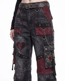 Close-up of women's cargo jeans showing gothic patchwork, metal rings, chain details, and premium washed denim on baggy cargo pants.