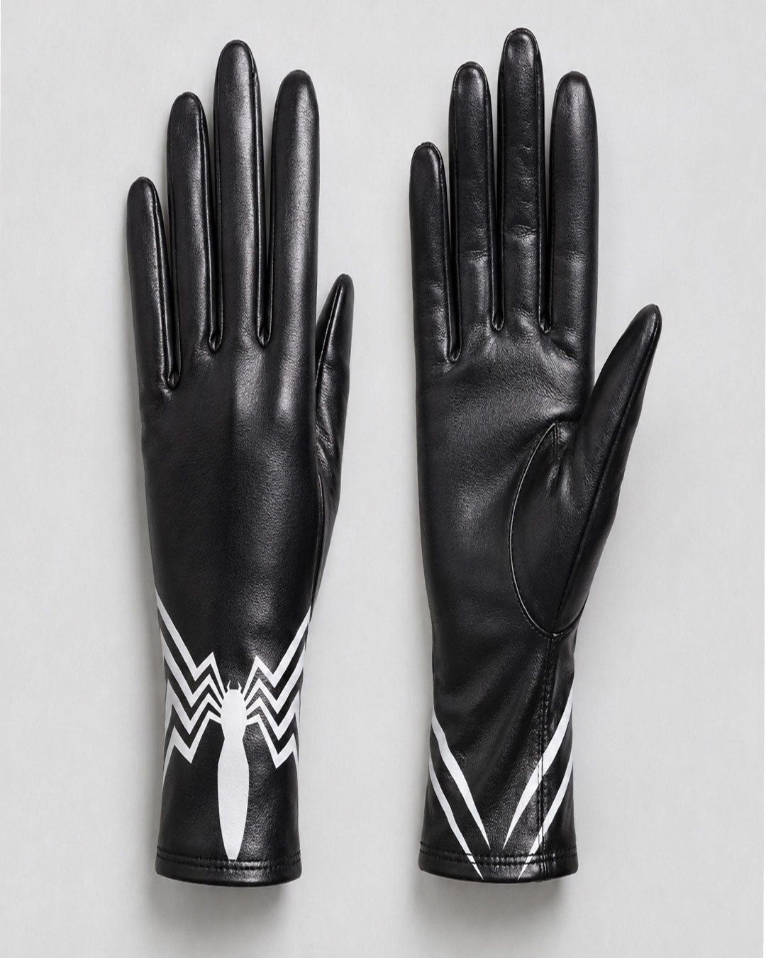 A pair of black leather gloves shown flat against a light gray background, featuring a white spider emblem and white diagonal stripe details near the cuffs.