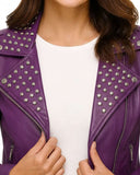 Close-up of purple studded biker jacket with silver studs on collar and lapels worn over white top