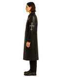 Side view of black Gothic Cross Long Leather Coat with silver cross embroidery on sleeve worn by model