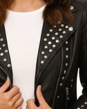 Black Studded Leather Jacket with silver-tone studs and asymmetrical zip closure on model wearing white top