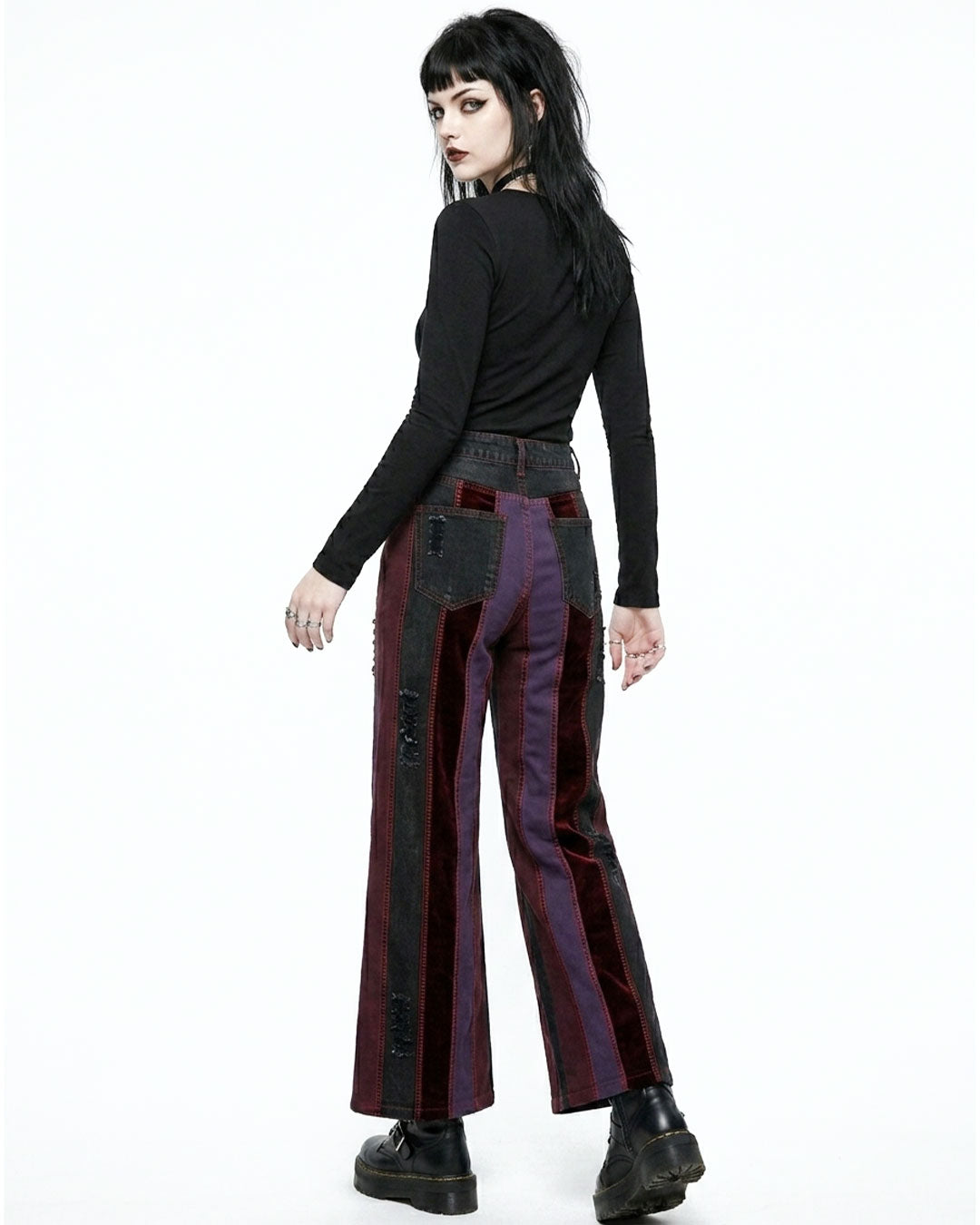 Person wearing a black top and striped pants on a white background