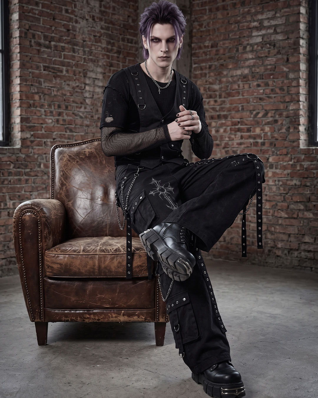 Gothic model wearing cargo black pants mens with cross print in industrial setting
