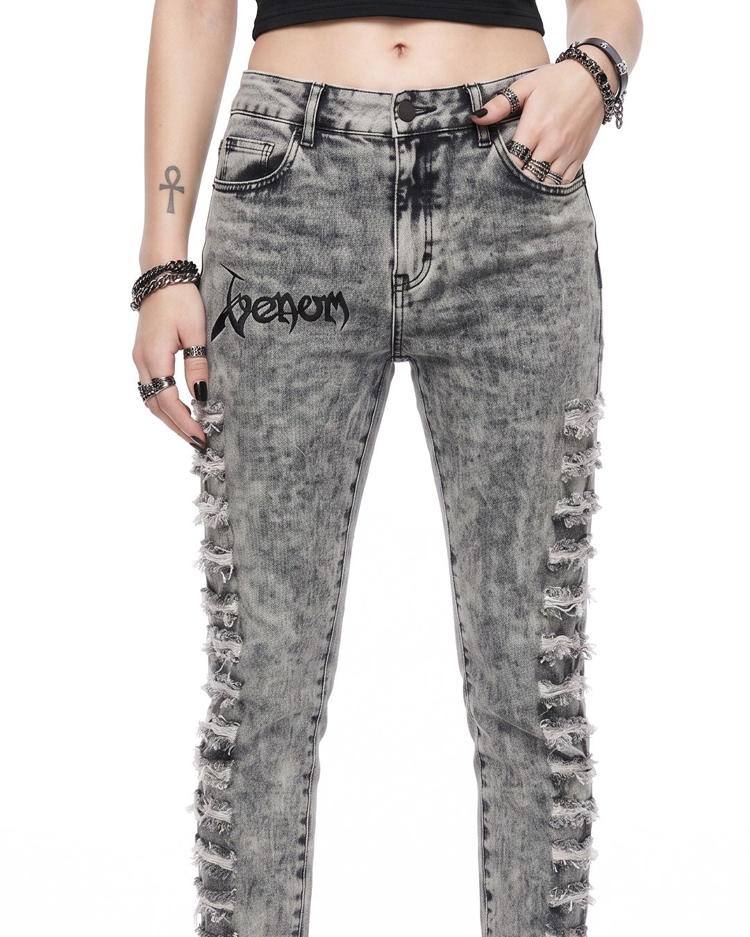 Close-up of grey skinny jeans women waistband with Venom logo print and shredded denim rips
