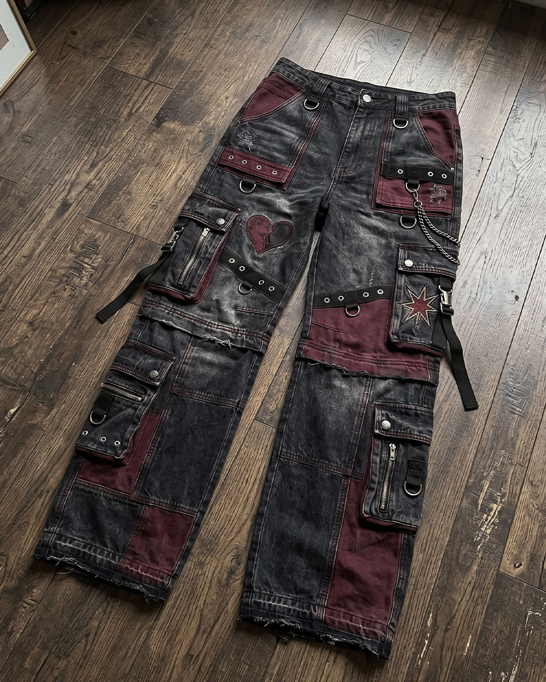 Front view of women's baggy cargo pants featuring goth cargo pants styling with oversized utility pockets, patchwork panels, and washed black denim.