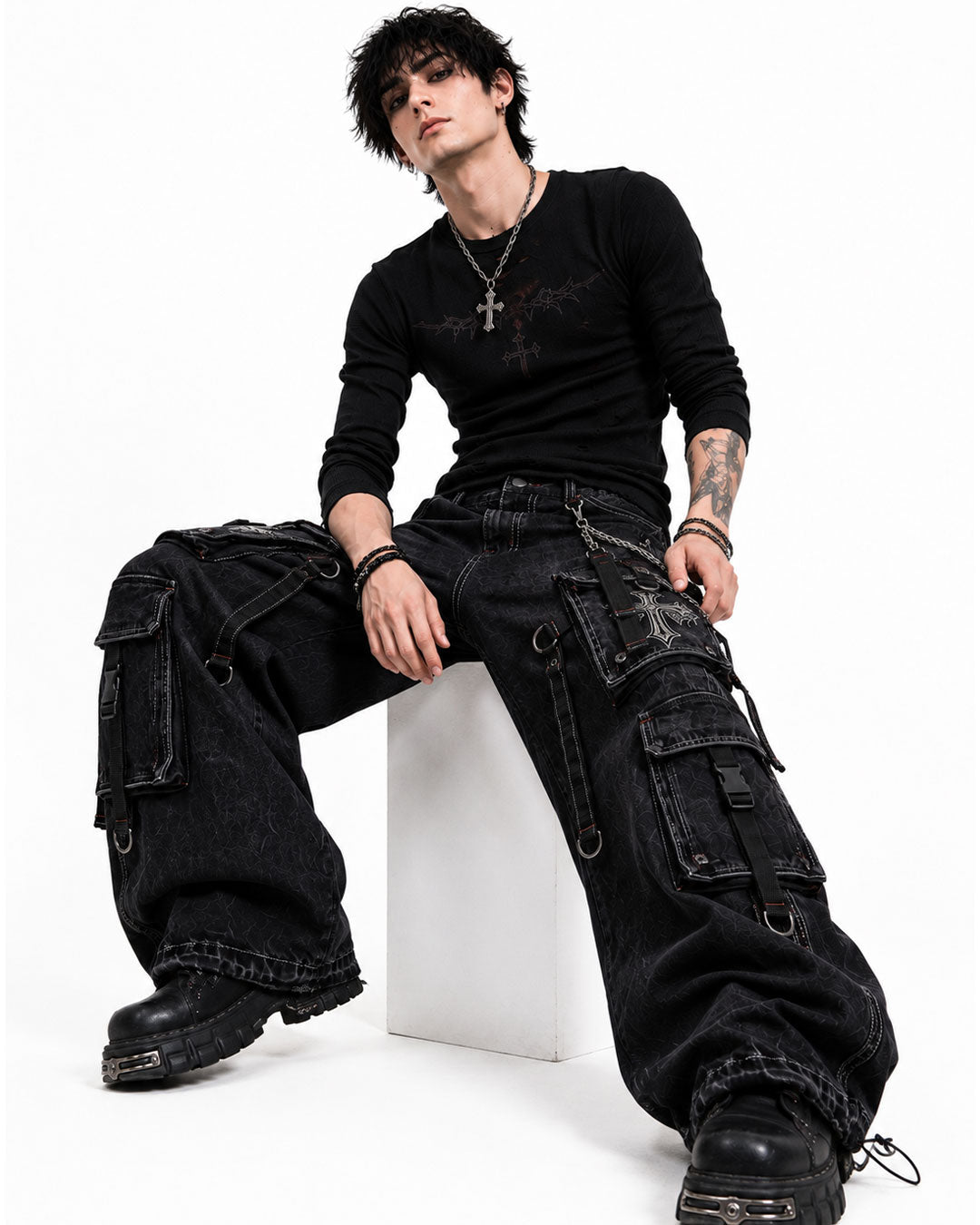 Male model sitting in black gothic cargo pants and boots