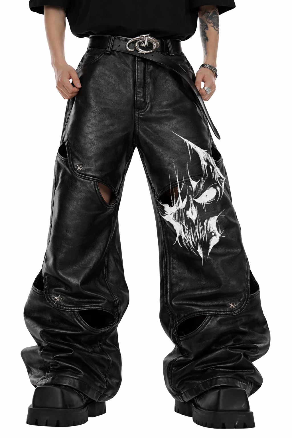 Gothic leather pants for men in black with wide-leg fit, leather-look finish, bold front graphic detail, and oversized alternative streetwear styling shown in lifestyle front and back view.