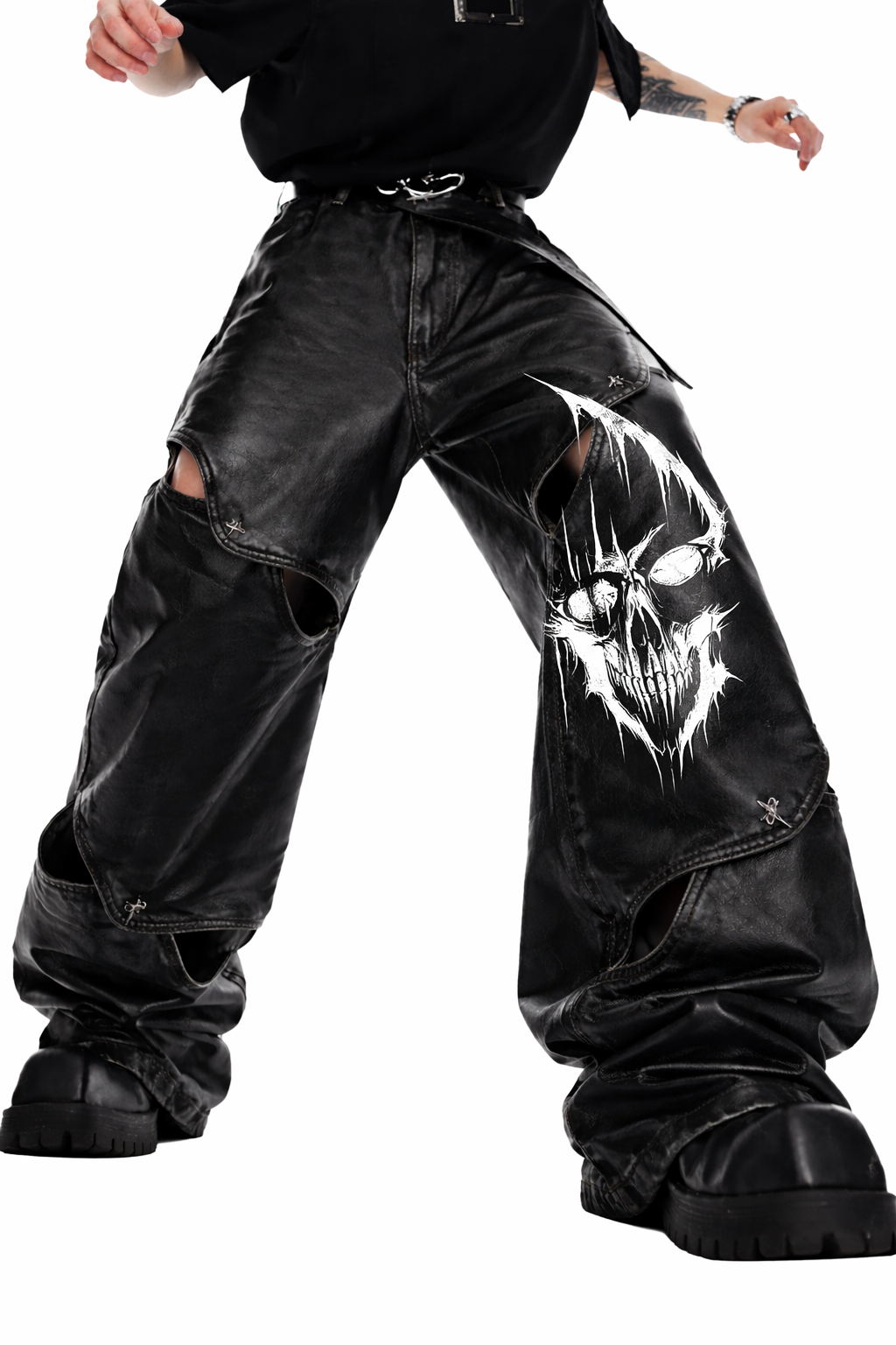 Gothic leather pants for men in black with wide-leg fit, leather-look finish, bold front graphic detail, and oversized alternative streetwear styling shown in lifestyle front and back view.