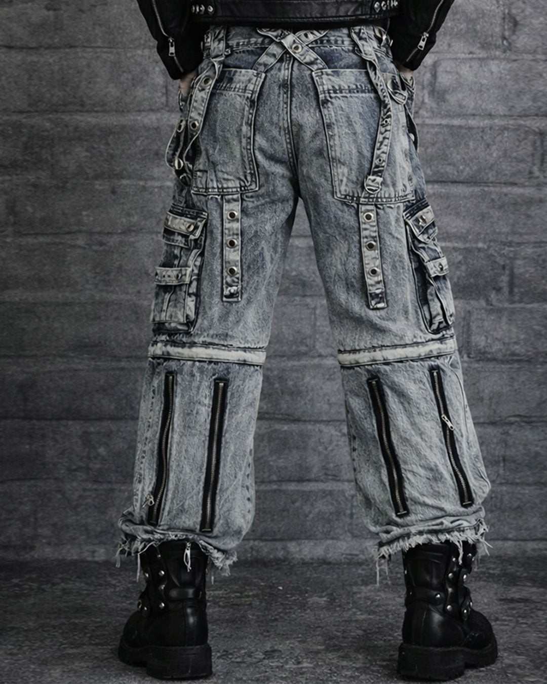 Men's black cargo jeans with baggy fit, multiple utility pockets, strap details, and washed dark finish shown in front and back view on model.