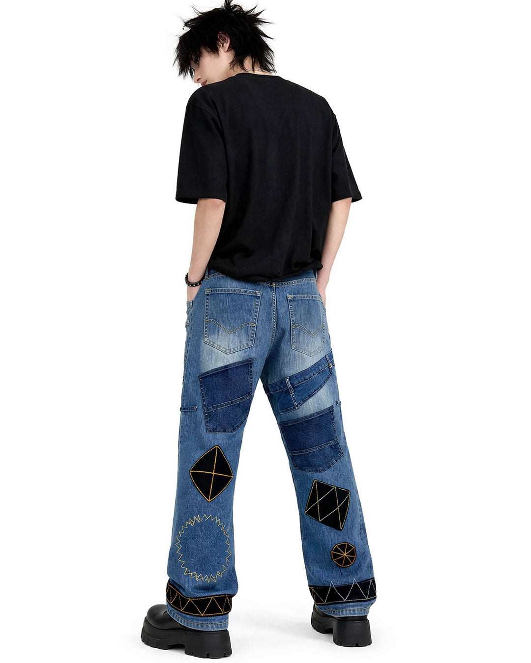 Black patchwork denim jeans with distressed finish, multi-pocket utility design, and wide-leg streetwear fit.