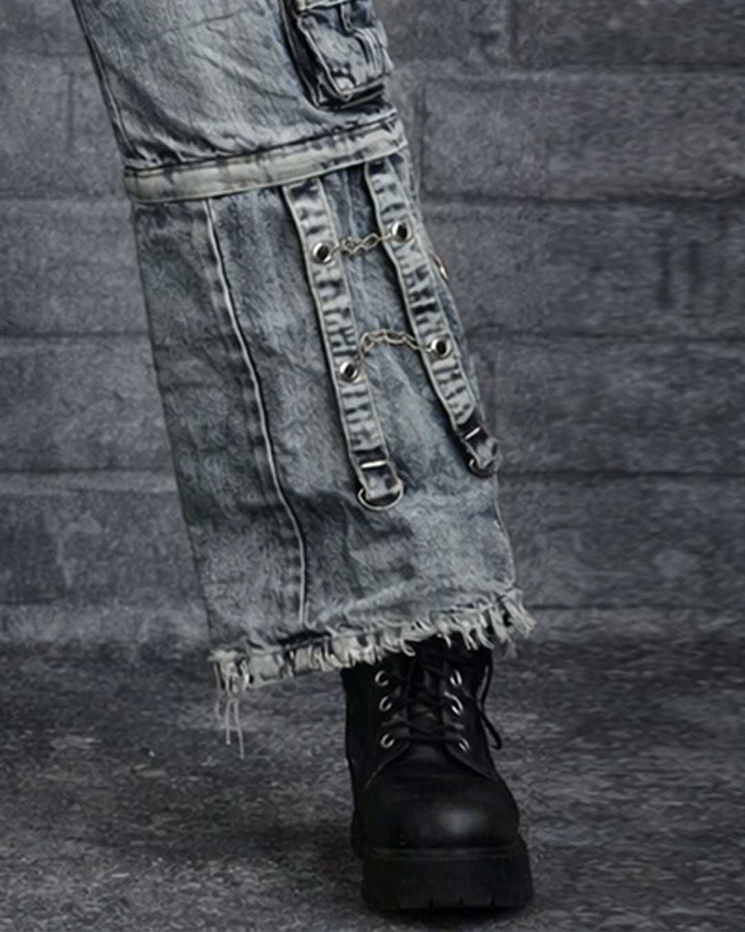 Men's black cargo jeans with baggy fit, multiple utility pockets, strap details, and washed dark finish shown in front and back view on model.