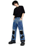 Black patchwork denim jeans with distressed finish, multi-pocket utility design, and wide-leg streetwear fit.