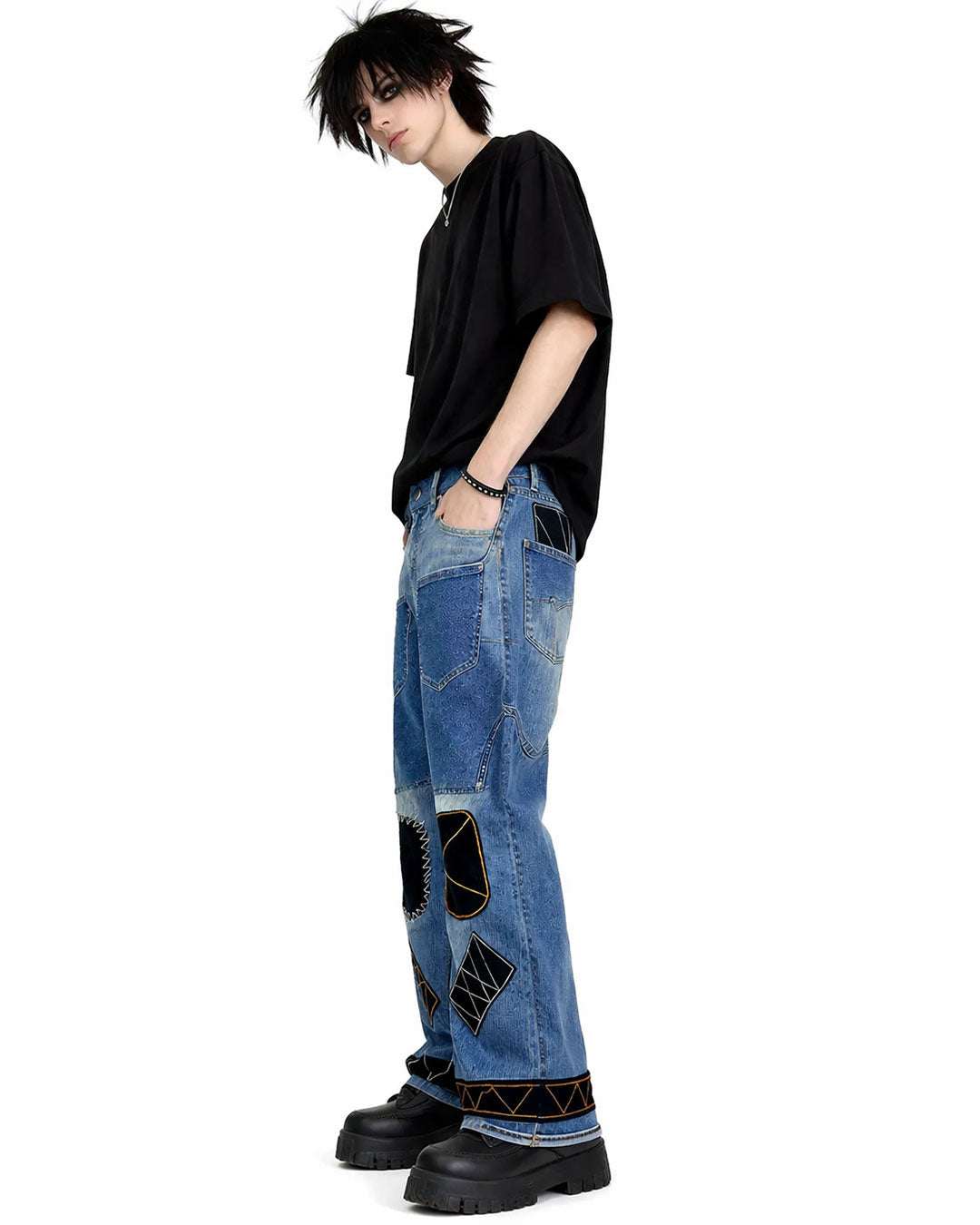 Black patchwork denim jeans with distressed finish, multi-pocket utility design, and wide-leg streetwear fit.