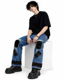 Black patchwork denim jeans with distressed finish, multi-pocket utility design, and wide-leg streetwear fit.